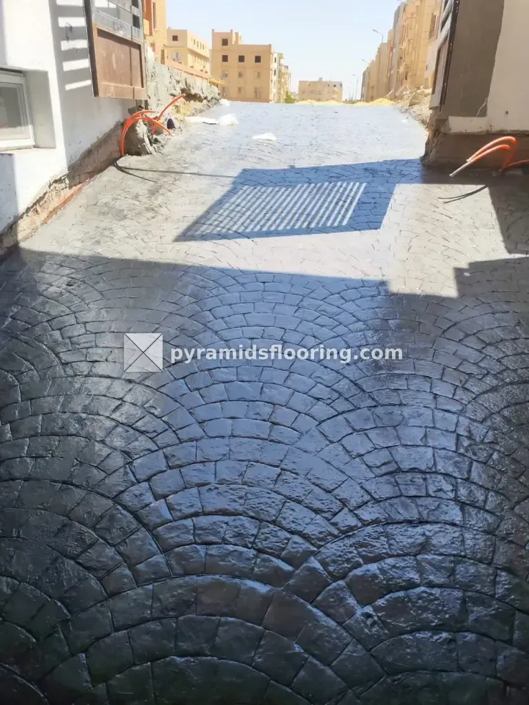 مدخل عمارة بخرسانة مطبوعة لامعة بعد السيلر وظل البوابة